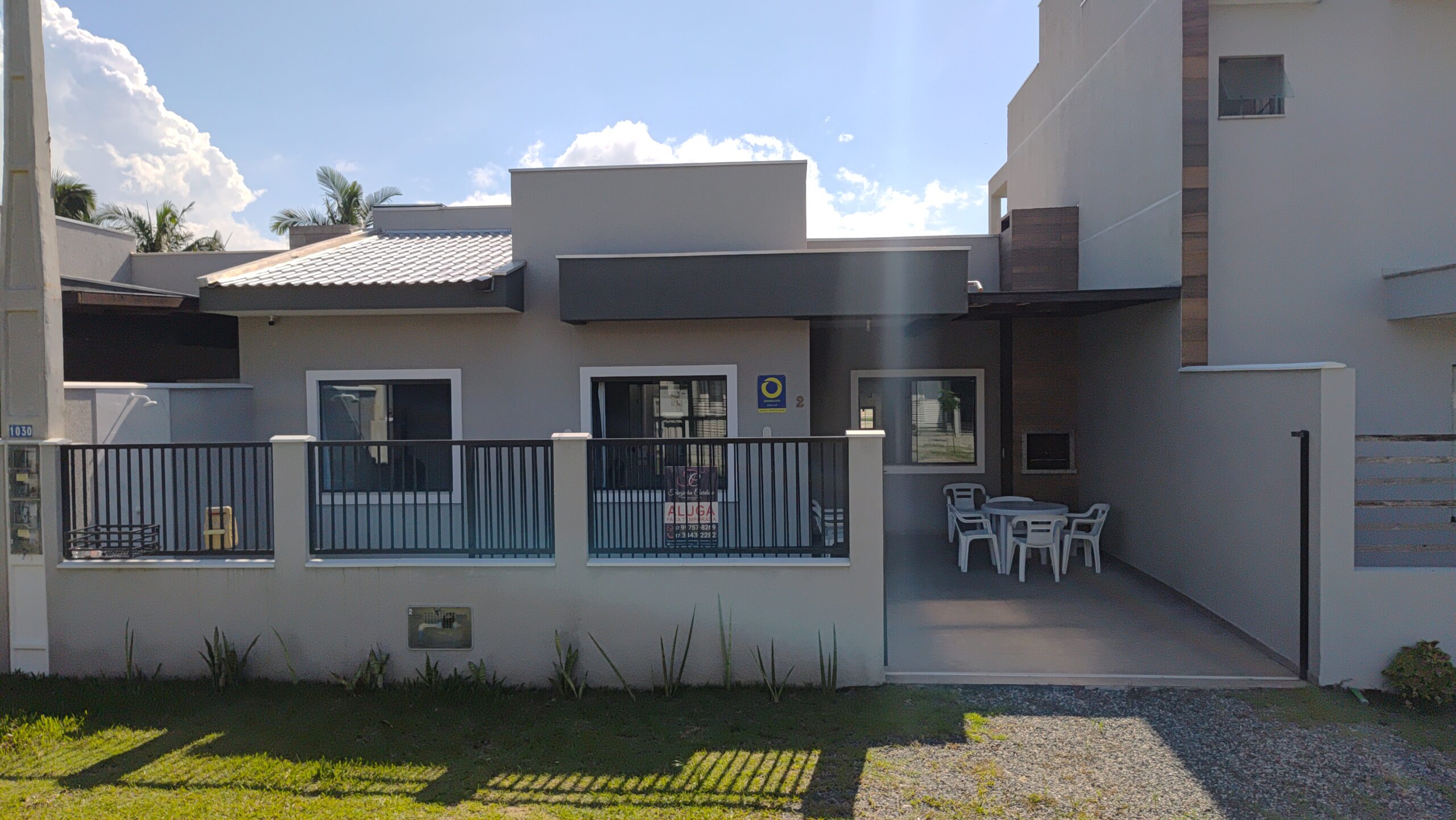 Casa geminada a venda ou aluguel, com acabamento moderno, portão deslizante e garagem com churrasqueira e 2 janelas.