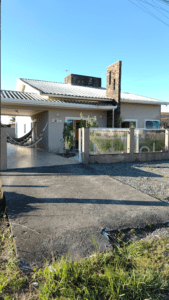 Casa com piscina e design moderno, com portões de vidro e redes na garagem.