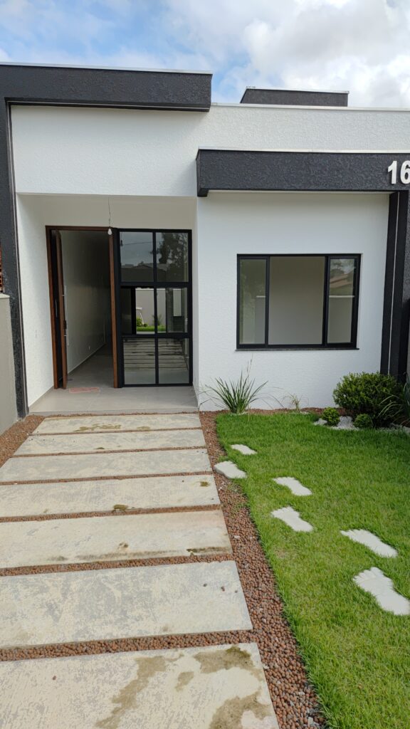 Casa moderna à venda com design clean, com gramado verde e janelas grandes de vidro.