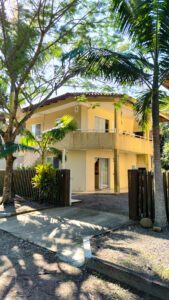 Apartamento 200 metros da praia para aluguel mensal em Itapoá, com portas de vidro, palmeiras e sacada.